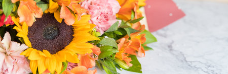 Fresh Bouquet of yellow sunflowers and pink carnations on marble background. flower shop. A variant of a bouquet on an autumn theme, for Thanksgiving.の写真素材