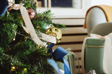 Christmas tree with toys in blue and golden color.christmas tree in living room, decorated with blue ornaments and garland, lots of presents under the tree.winter holidaysの写真素材