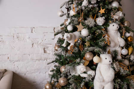 beautiful big Christmas tree decorated with balls and toys,holiday christmas mood gifts with ribbons.Christmas tree decorated with soft toys, tree with polar bear.cozy interiorの写真素材