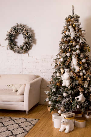 beautiful big Christmas tree decorated with balls and toys,holiday christmas mood gifts with ribbons.Christmas tree decorated with soft toys, tree with polar bear.cozy interiorの写真素材