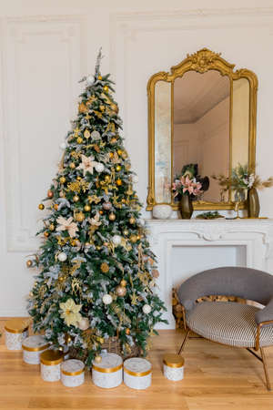 Interior living room with a Christmas tree and decorations.Luxury apartment decorated for christmas or new year. classical interior of a white room.golden pastel colorsの写真素材