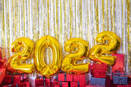 2022 golden foil balloons with present boxes and confetti. Happy new year and festive concept.party...
