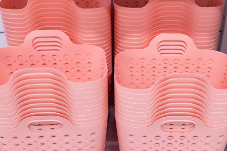 Empty plastic Laundry Basket as background. Pink, coral plastic handle basket.Stack of plastic bagsの写真素材