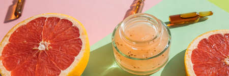Organic Serum with Vitamin C, a bottle of serum, grapefruit.Ampules with vitamin C injection and citrus fruit slices on color backgroundの写真素材