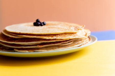 stack of delicious pancakes with fresh blueberries on bright background, closeup.Delicious thin...