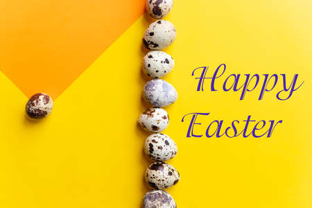 Easter greeting card. Happy Easter text. Beautiful postcard, seasons greetings.quail eggs on a yellow background. decoration, minimalist designの写真素材