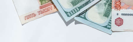 Russian rubles on background of US dollars. Concept of exchange rate, sanctions, falling ruble.The Russian money and the American dollar on a white background. Currency exchange. The money crisis.の写真素材