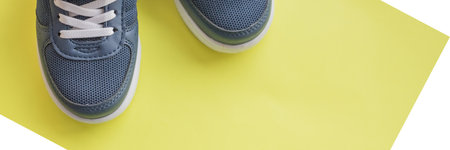 Blue childrens sports shoes on yellow background. The concept of using textile shoes by children, physical activity of children, care for health. new sport shoes.copy space.web bannerの写真素材