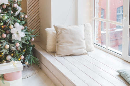 warm cozy beautiful modern design of the room in delicate light colors decorated with Christmas tree and decorative elements. Stylish Christmas interior decorated in pastel colors. Comfort home.の写真素材