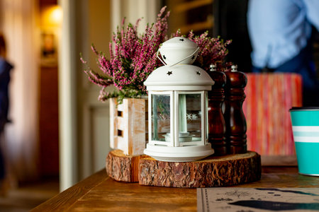 Autumn still life in the cafe, at home. Heather, white lantern, spikelets in wooden boxes, cozy...