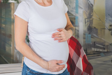 pregnant woman holds her belly.pregnancy, love, holidays, people and expectation concept - happy...