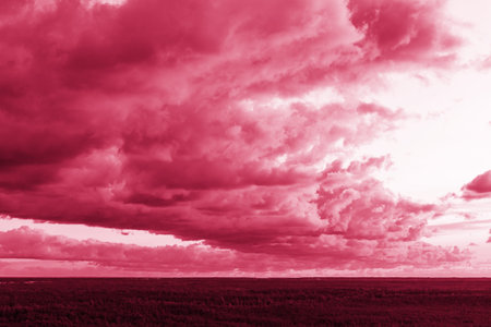 Trendy color of the year 2023. Sky with rain clouds toned in viva magenta color.sky abstract...