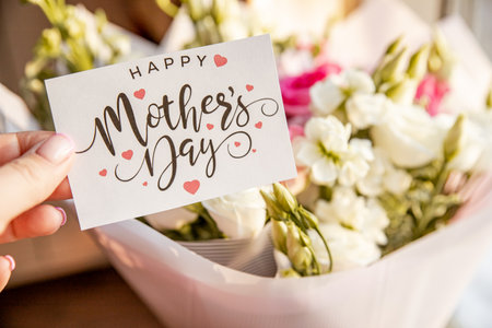 flower composition of light roses and eustoma closeup. hand with Text Happy mothers day. Bright bouquet with tender flowers.Greetings card,sweet wish concept.の写真素材