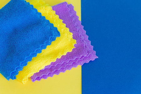 Flat lay composition with microfiber rags on a yellow blue background with a copy space. Home Care Concept.cleaning toolsの写真素材