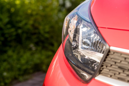 Headlights and hood of sport red car , outdoor.Concept of car detailing and paint protection background.の写真素材