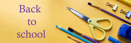 Back to school concept. Colorful stationary school supplies, copy space.Various stationery items on a yellow background. Paperclips. Clips for paper. Brushesの写真素材