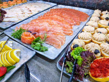 Smoked salmon fillet on the table. Buffet.Many pieces of fresh salmon fish.served table at open-air restaurant on beachの写真素材
