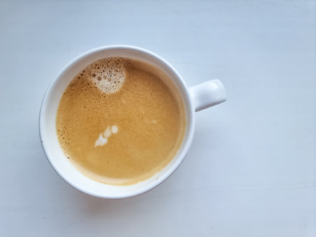 cup of cappuccino. Beautiful foam, ceramic cups, place for text.Hot art Latte Coffee in a cup on white tableの写真素材