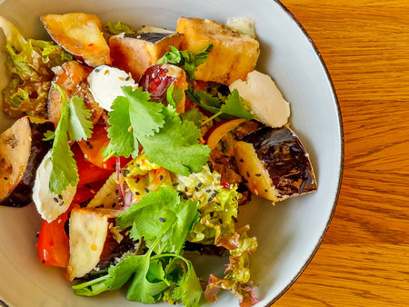 Vegetarian Eggplant Salad with Baked Aubergine, Tomatoes and Cilantro Close Up. Macro Photo of Grilled Eggplants and Cottage Cheese with Parsley, Sesame Seeds and Oil.Warm Salad with crispy eggplantの写真素材
