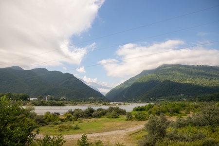 landscape with mountain river among spruce forest. beautiful sunny morning.white fluffy cloud on the sky.Picturesque mountain valley.wild Nature Reserveの写真素材