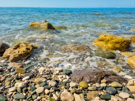 Stones on beach and sea water.Waves in sea near coastline on empty pebble beach. Coast pebbles. Shore landscape on Europe resort. Ocean shoreline scenic.の写真素材