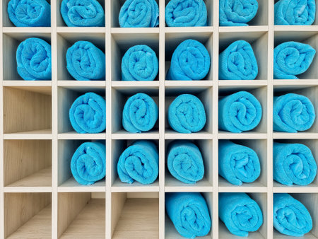 Stack of rolled towels in hotel near beach. Spa resort.Beach bath towel rolls blue fabric texture cloth background used for swimming poolの写真素材