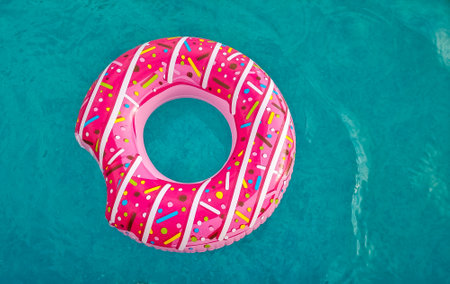 bright pink inflatable ring floating in swimming pool. Vacation concept with copy spaceの写真素材