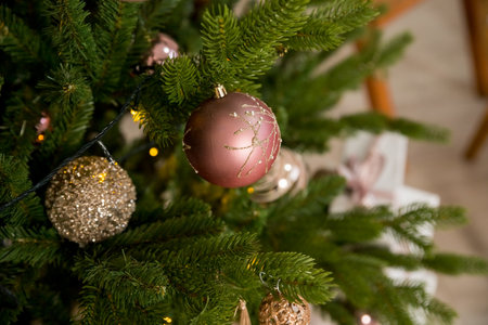 christmas tree decoration. toys and garlands. festive decor during winter holidays.Glittery ornament hangs from bough of fresh Christmas tree.Festive atmosphere.の写真素材