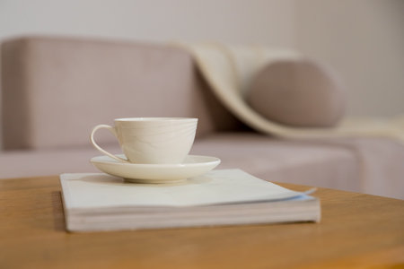 Work from home, renting apartment, buying. beige sofa with pillows, table with cup of hot drink, shelves in living room interior.Concept of morning cup of coffee, good start to the day, a cozy home.の写真素材