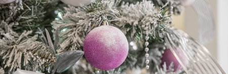 Christmas tree with lilac pink toys and garland. bright stylish classic living room or bedroom. Fir...