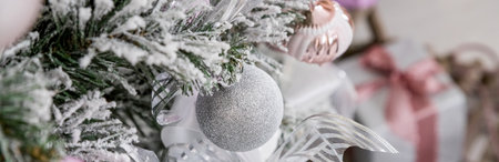 Christmas tree with lilac pink toys and garland. bright stylish classic living room or bedroom. Fir tree with silver, pink balls, silver stars and toys. happy new year. Home decoration. web bannerの写真素材