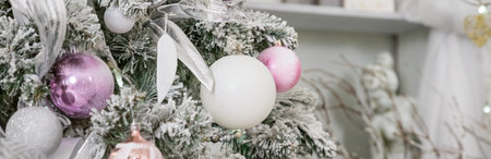 Christmas tree with lilac pink toys and garland. bright stylish classic living room or bedroom. Fir tree with silver, pink balls, silver stars and toys. happy new year. Home decoration. web bannerの写真素材
