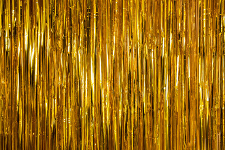 Metallic gold foil tinsel fringe decoration curtain. Birthday, wedding, Christmas, New Year party decoration background. Party decor.の写真素材