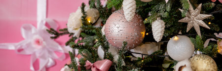 Giftboxes, pink and white christmas decorations balls hanging on a christmas tree. pink gift boxes decorated with ribbon on floor .Concept New Year celebration background.Winter holidays conceptの写真素材