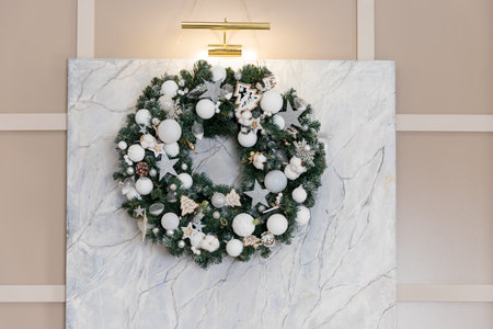 A decorative wreath from fir branches, silver balls, stars, and white ribbons for the festive holiday season. winter decorationの写真素材