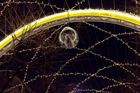 Stylish christmas golden star illumination, gold baubles, lights bokeh on front of building at...