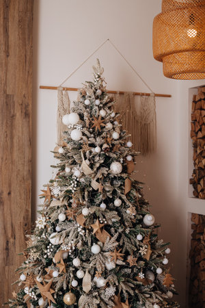 interior with christmas tree decorated with craft paper toys, balls, tinsel. Beige cozy loft with lights. Vintage interior.white balls on the Christmas tree. happy new New Year.の写真素材