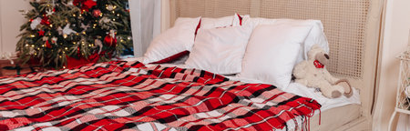 Winter Xmas Hygge home decor. Festive cozy bedroom in Skandinavian style with bed and two snow-covered decorated christmas tree with gifts. Concept new year and holidays. Interior design bedroom.の写真素材