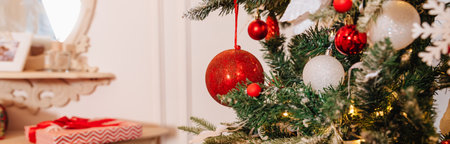 Christmas decorations on the branches fir, sparkling and fairy background. Red and white New Years Christmas ornaments on the tree, glass balls and garlands in the house.web bannerの写真素材