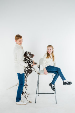 woman and toddler girl play with dog puppy dalmatian.pet and child ,generation therapy ,canisterapie,emotion, mental health. people hugging and kissing a dog, playing with puppy on a white backgroundの写真素材