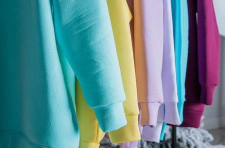 Sweatshirts on hangers in the clothing store for sale. Row of colorful cashmere hoodies for youth. Multi-colored sweatshirts in a clothes stand in the mall.fashion womans sweats hoodieの写真素材