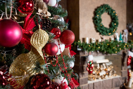 Beautiful new year room with decorated Christmas tree, gifts and fireplace with the glowing lights at night. The idea for postcards. decorated fir tree with garlands and ballsの写真素材