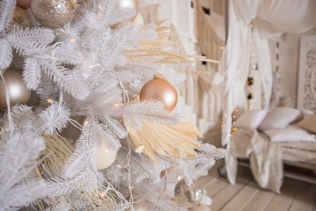 White Christmas tree with pastel colored decoration with balls on fir branches with blurred background.Holiday decoration.Christmas and New Year holidays backgroundの写真素材