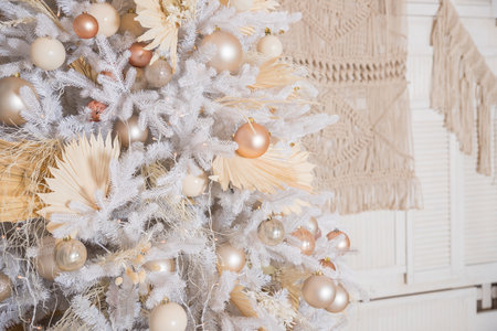 White Christmas tree with pastel colored decoration with balls on fir branches with blurred background.Holiday decoration.Christmas and New Year holidays backgroundの写真素材