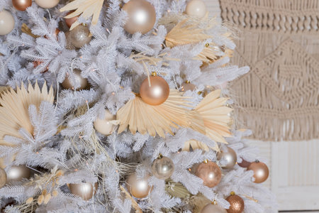 Close up of beautiful white fir branches with shiny golden, silver and white baubles or balls, shiny ornaments and garland lights, home Decoration.Festive new 2024 yearの写真素材