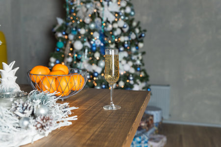 new years still life, 2 glasses of champagne, tangerines on the table on the background of the Christmas tree.Christmas and new year dietary sweetnessの写真素材