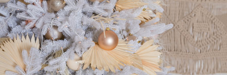 Close up of beautiful white fir branches with shiny golden, silver and white baubles or balls, shiny ornaments and garland lights, home Decoration.Festive new 2024 year. web banner.の写真素材