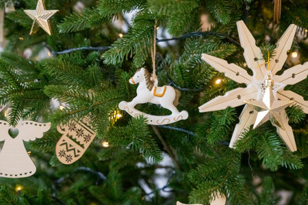 Handmade Christmas tree decoration hanging on tree with balls and wooden toys. Christmas zero-waste ornaments. wooden eco toys. New year decor.の写真素材