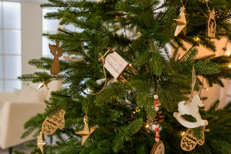 Handmade Christmas tree decoration hanging on tree with balls and wooden toys. Christmas zero-waste ornaments. wooden eco toys. New year decor.の写真素材