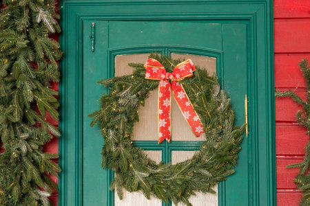 Wreath decoration at door for Christmas holiday.Traditional christmas wreath on old wooden green door in european city street. Stylish christmas street decor, Winter holidaysの写真素材